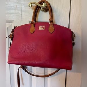 Dooney and Burke red pebbled leather purse with cross body strap.